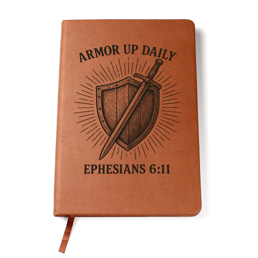 Brown leather prayer journal engraved with a shield and sword design and the words “Armor Up Daily – Ephesians 6:11.”