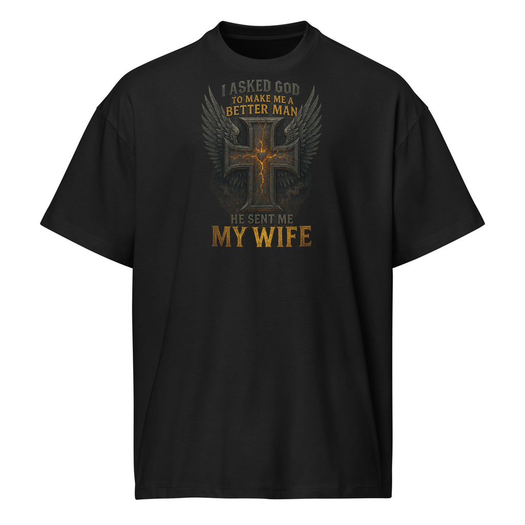 Black men’s box tee with Christian graphic design of cross with wings and text ‘I asked God to make me a better man, He sent me my wife’ – faith-based marriage shirt.