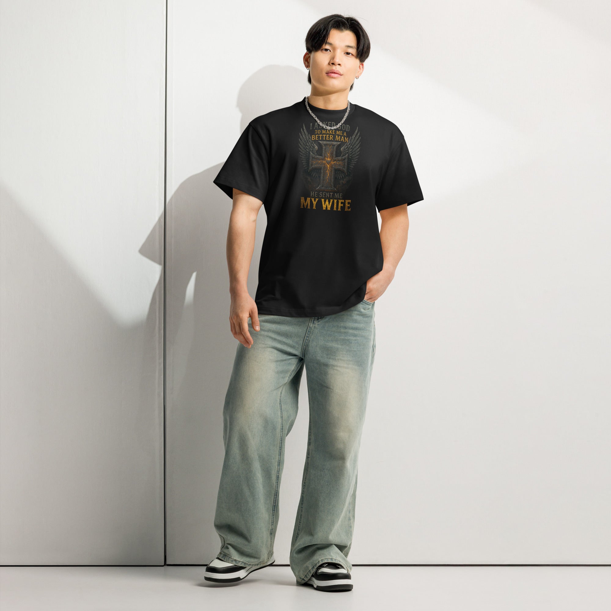 Black men’s box tee with Christian graphic design of cross with wings and text ‘I asked God to make me a better man, He sent me my wife’ – faith-based marriage shirt.