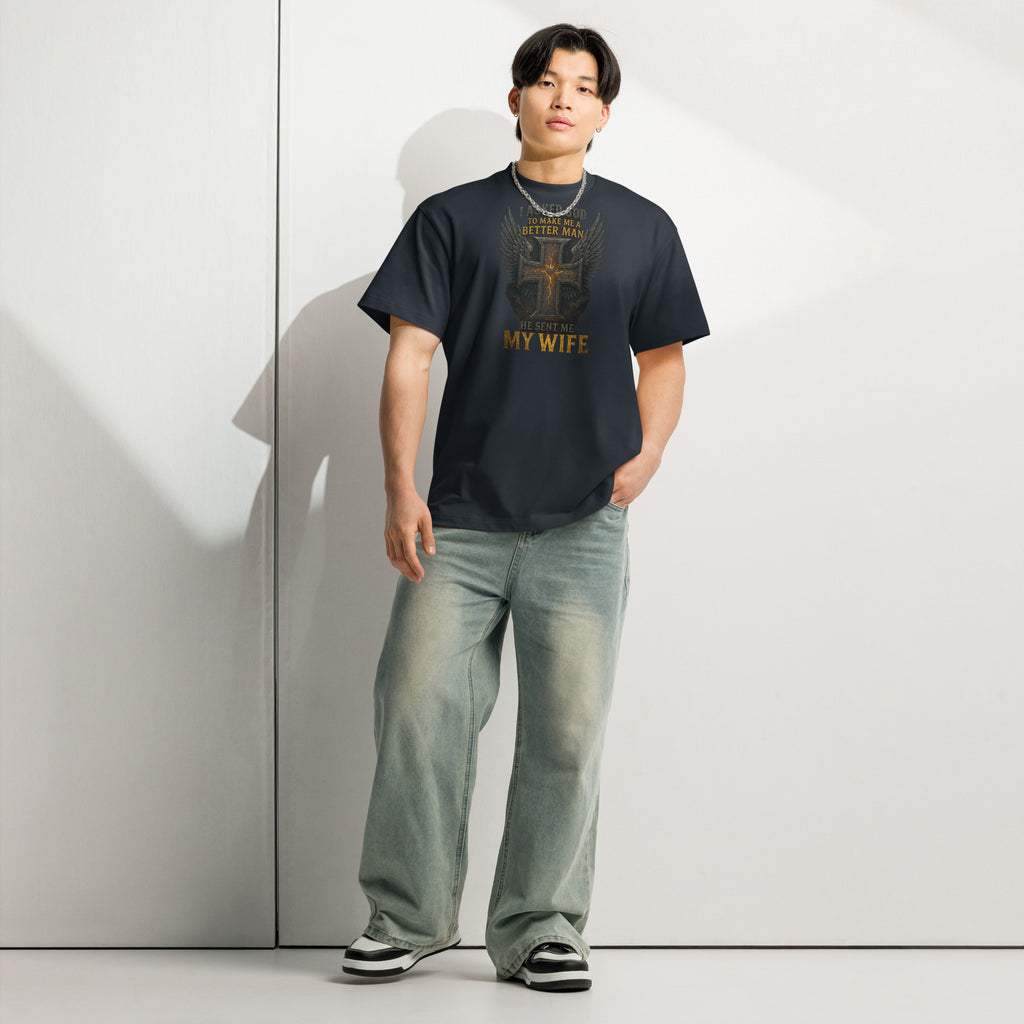Navy men’s box tee with Christian graphic design of cross with wings and text ‘I asked God to make me a better man, He sent me my wife’ – faith-based marriage shirt.